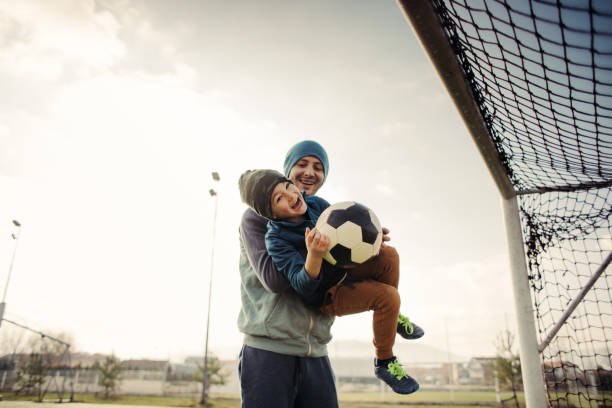 отец и сын играют в футбол на открытом воздухе - soccer goal net winning стоковые фото и изображения