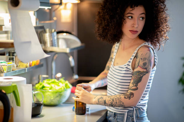 istock Young tattoed woman in kitchen 1149437206
