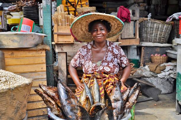 Portrait Of Smiling Woman Selling Fish At Market Photo taken in Accra, Ghana ghana stock pictures, royalty-free photos & images