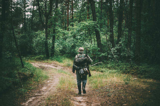 istock Rear View Of Man Wearing Uniform Walking On Footpath In Forest 1149439698