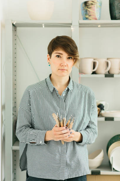 istock girl potter's holds carving tools on ceramics 1149441199