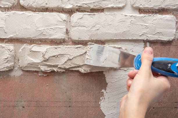 istock Plasterer manually works with a spatula and smooths the plaster on the wall 1149441593