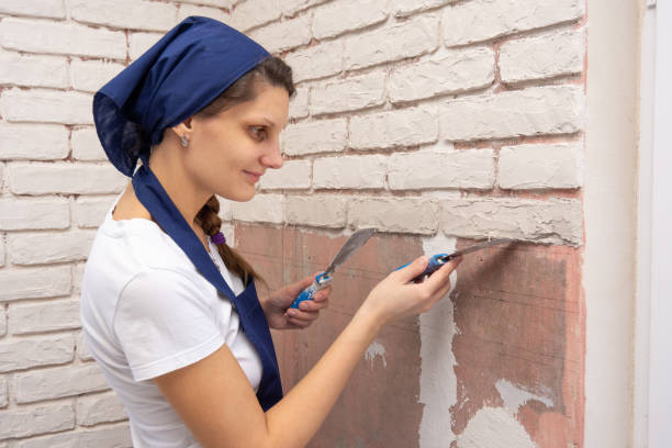 istock Plasterer girl forms from a plaster mass bricks on the wall 1149441611