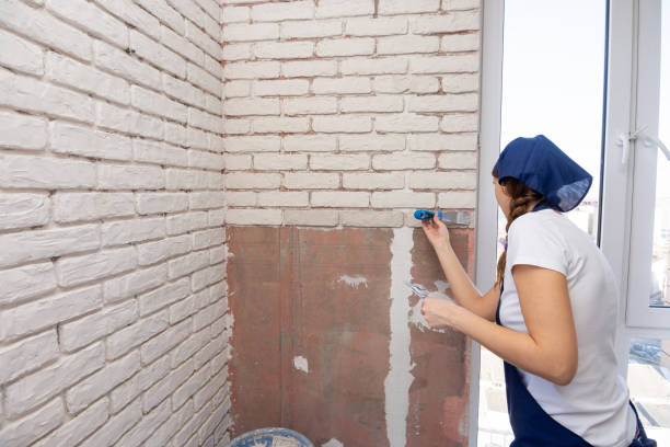 istock The girl manually plasters imitation of bricks on the wall 1149441616