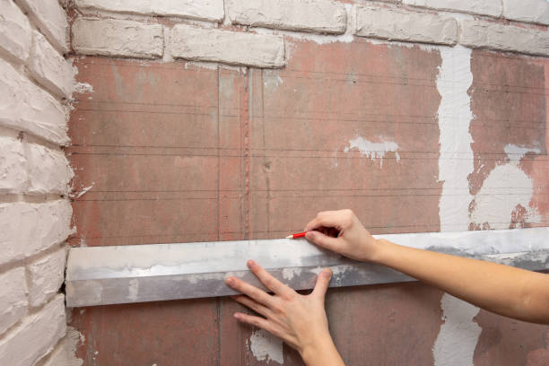the girl draws on the wall of the line for the exact location of bricks - plaster plasterer work tool child imagens e fotografias de stock