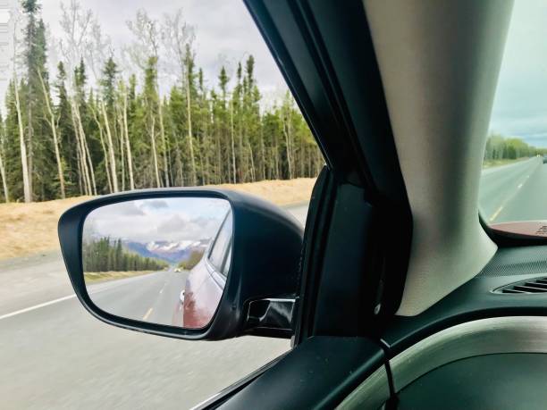 Driving on the road with 360 degree view of wild Alaska The beautiful mountain close by town of Homer in South of Alaska is pictured in the sideview mirror of my car. alaska us state photos stock pictures, royalty-free photos & images