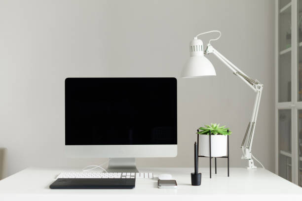 istock Modern office desk table. Desktop computer, white lamp, graphics tablet, keyboard, mouse, pen and succulent plant. Copy space. Scandinavian home, minimalistic style. 1149445633