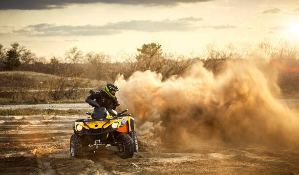 Racing powerful quad bike on the difficult sand in the summer. Racing in the sand on a four-wheel drive quad. quadbike photos stock pictures, royalty-free photos & images