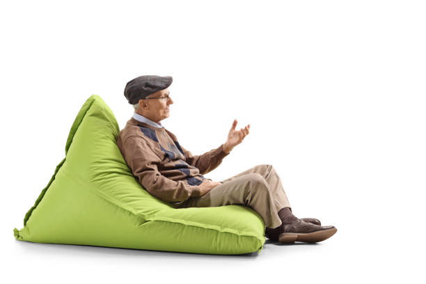 istock Senior man sitting on a bean bag and gesturing with hand 1149457394