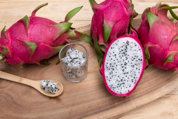 istock Organic white fresh dragon fruit cut into half on wooden chopping board, copy space 1149462366