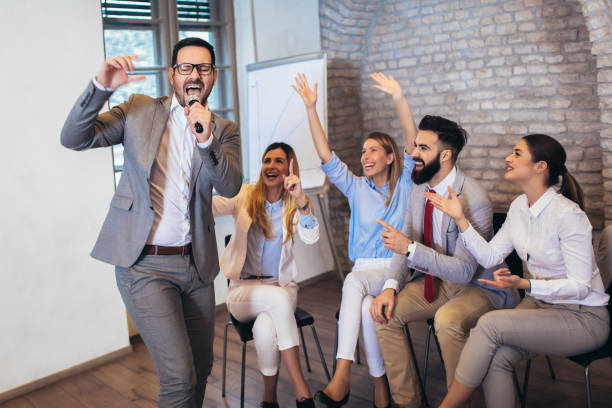 istock Business people singing karaoke in modern office 1149462858