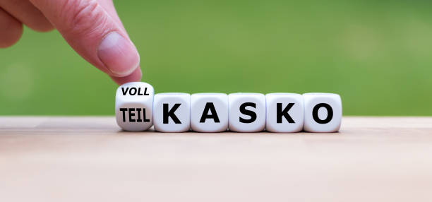 hand gira un dado e cambia la parola tedesca "teilkasko" (in parte copertina completa" in inglese) in "vollkasko" ("copertina completa" in inglese). - partly foto e immagini stock