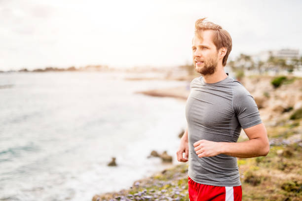 istock Man running on the coastline during sunset. 1149472507