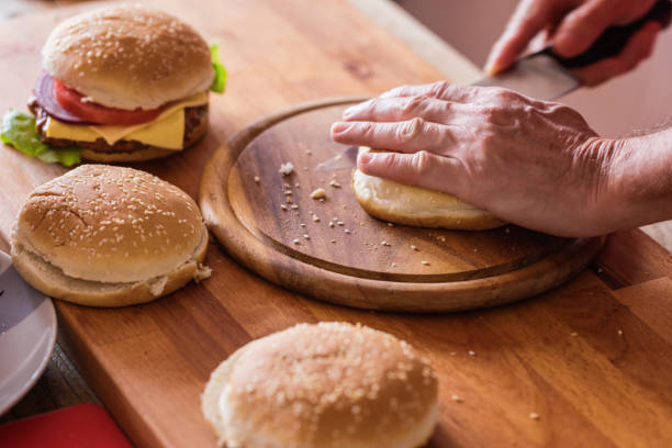istock Hamburger preparing, cutting burger bun, close up 1149477784