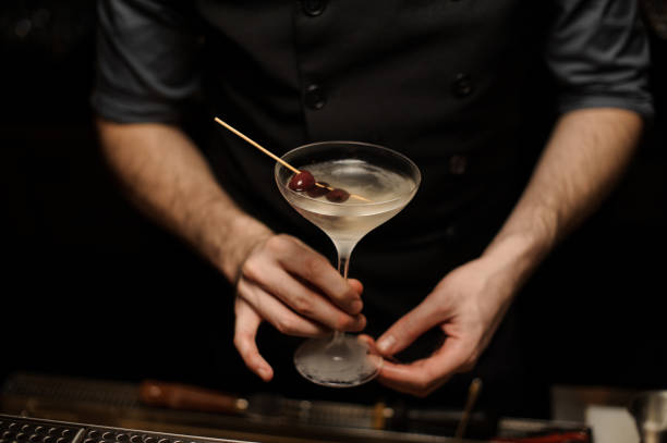 istock Bartender holding alcohol cocktail with olives on toothpick 1149479754