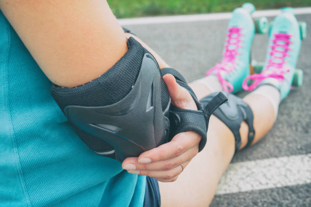 istock Woman rollerskater putting on elbow protector pads on her hand 1149483058