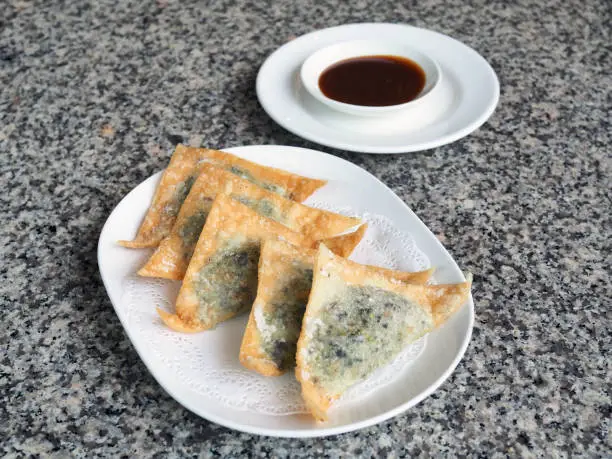 Photo of Chinese fried dumplings vegetable (wonton) served with sweet sauce.