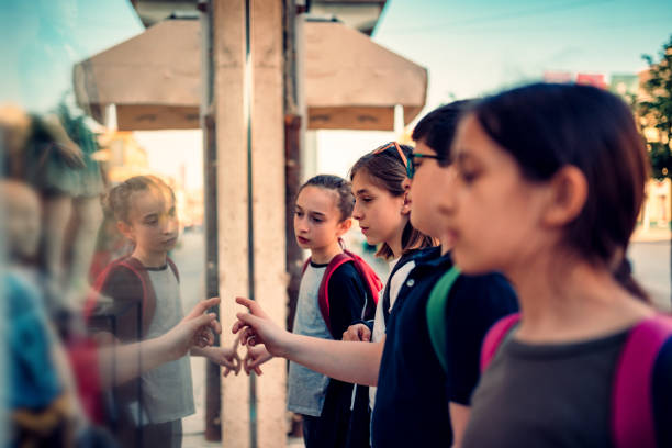 istock Group of school kids looking at shop window 1149484557