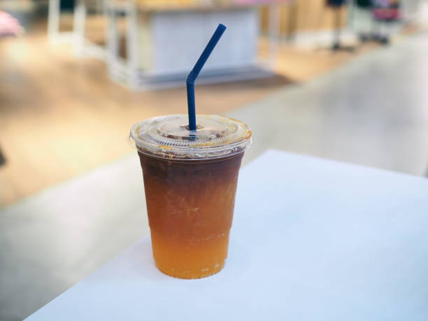 istock A refreshing plastic glass of iced  espresso mixed with peach on the table. 1149484562
