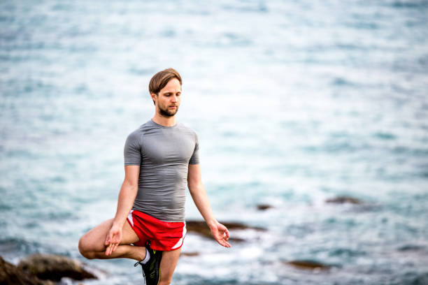 istock Young man doing yoga by the sea. 1149484945