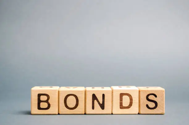 Photo of Wooden blocks with the word Bonds. A bond is a security that indicates that the investor has provided a loan to the issuer. Equivalent loan. Unsecured and secured bonds