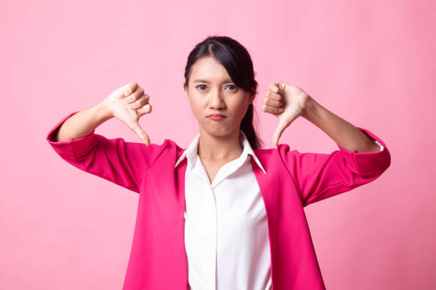 istock Unhappy Asian girl show thumbs down with both hands. 1149487600