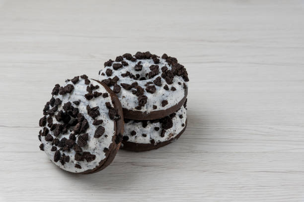 istock Donuts and coffee cup on a white wood background, close-up. 1149488605