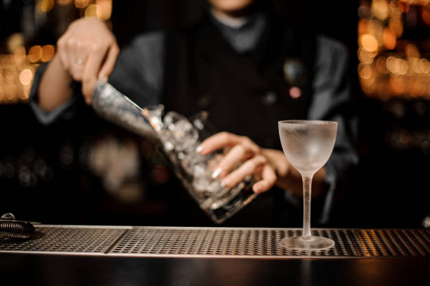 istock Female bartender adds ice in glass with ice scoop 1149489499