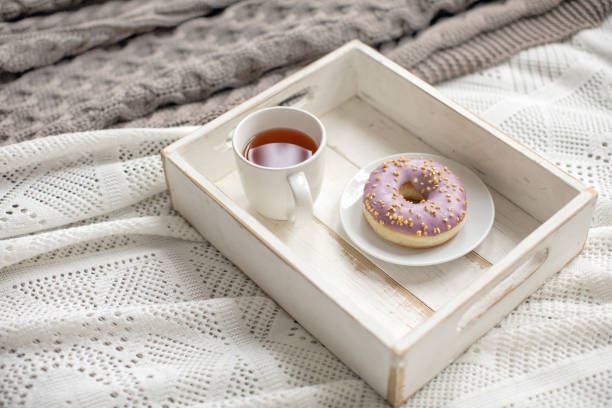 Wooden tray with tea and served doughnut
