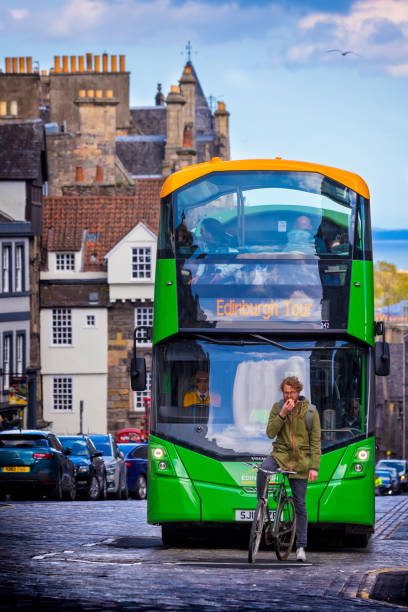 Edinburgh, United Kingdom - May 10, 2019: Tour Bus on The Royal Mile, Edinburgh, United Kingdom. The Royal Mile is the name given to a succession of streets forming the main thoroughfare of the Old Town of the city of Edinburgh in Scotland