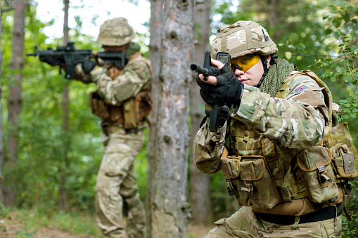 Military training - two fully armed British soldiers on a mission in forest.