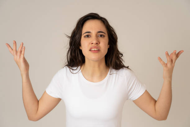 primo primo di giovane attraente donna latina frustrata nello stress con il viso furioso. sembra pazzo e deluso facendo gesti arrabbiati. in uno sfondo neutro. nelle espressioni facciali umane e nelle emozioni. - serious women human face teenager foto e immagini stock