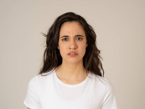 Close up of young attractive frustrated latin woman in stress with furious face. Looking mad and disappointed making angry gestures. In neutral background. In human facial expressions and emotions. stock photo