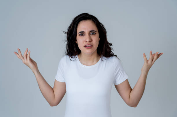 primo primo di giovane attraente donna latina frustrata nello stress con il viso furioso. sembra pazzo e deluso facendo gesti arrabbiati. in uno sfondo neutro. nelle espressioni facciali umane e nelle emozioni. - serious women human face teenager foto e immagini stock