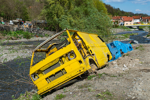 Krupanj, Serbia April 19, 2019: Waste of cars by the river in Serbia. Junk car embankment project.