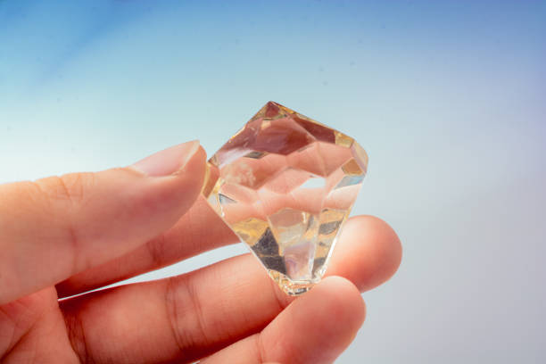 istock Hand holding a transparent diamond on white background 1149501818