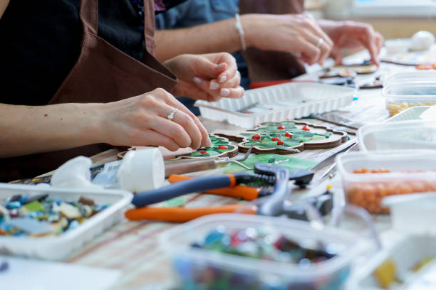 o artista fêmea das mãos recolhe o fim do mosaico acima - mosaic human hand craft artist - fotografias e filmes do acervo