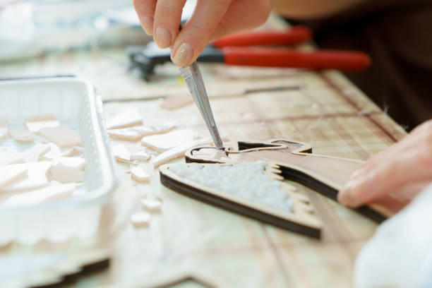 Female hands artist collect mosaic close up stock photo