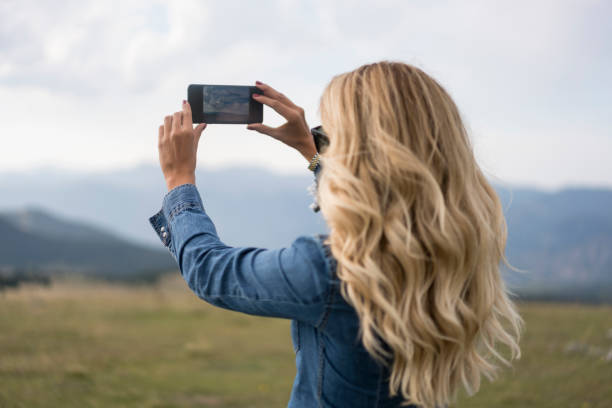 Young woman photographing the sunset