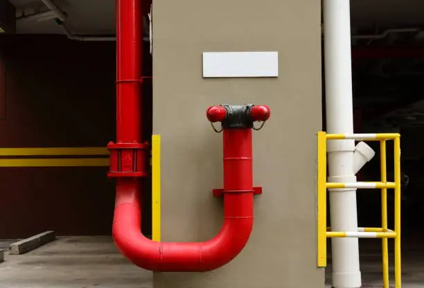 Closeup of siamese connection in car park area of a building, fire protection concept