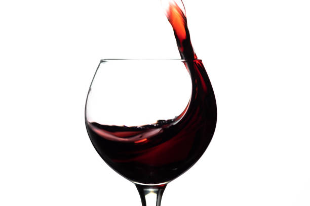 istock Red wine splash into glass on white background 1149514896