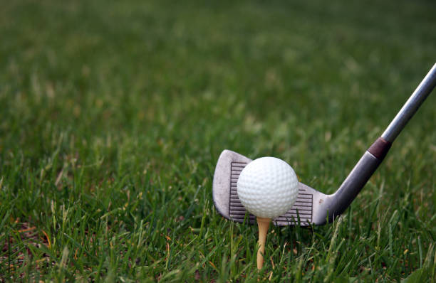 istock Golf ball on a tee and club ready to strike make a golfing background 1149518822