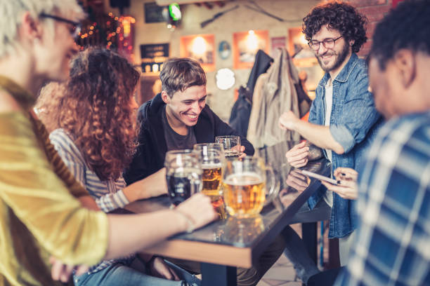 grupo de jóvenes, multirraciales personas que se divierten en un pub local - couple blond hair social gathering women fotografías e imágenes de stock