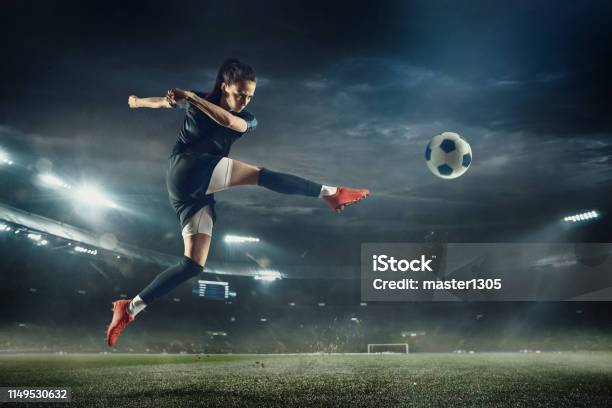 Female Soccer Player Kicking Ball At The Stadium Stock Photo - Download Image Now - Soccer, Soccer Ball, One Woman Only