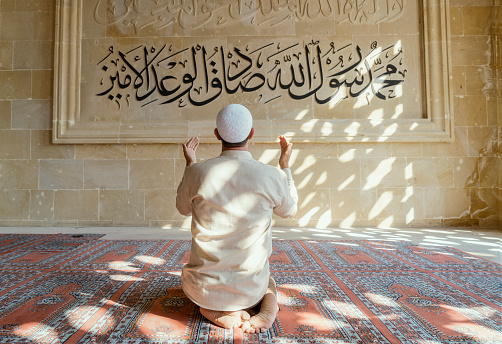 Muslim man is praying in mosque