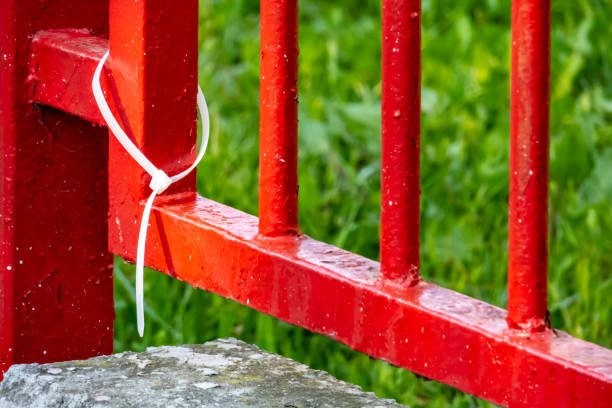 istock white plastic handcuffs and red garden iron fence 1149532102