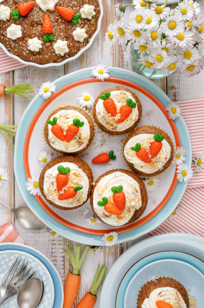 karotten-cupcakes mit mascarpone-creme mit marzipan-karotten auf einem teller dekoriert, oben ansicht. - muffin cheese bakery breakfast stock-fotos und bilder