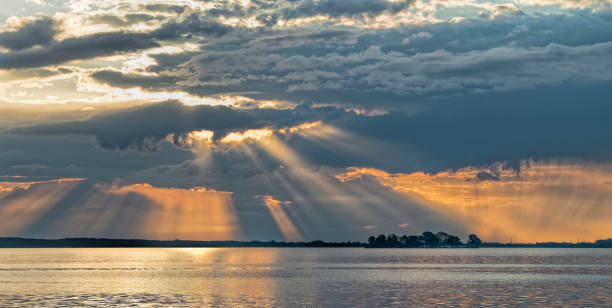 raggio di sole sul lago con drammatico paesaggio nuvoloso color arancio - steinhuder meer foto e immagini stock