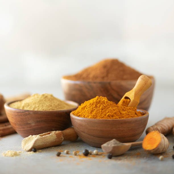 istock Ingredients for turmeric latte. Ground turmeric, curcuma root, cinnamon, ginger, black pepper on grey background. Spices for ayurvedic treatment. Alternative medicine concept 1149544851