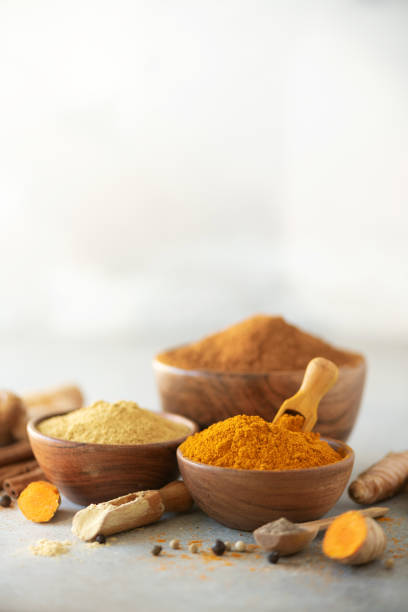istock Ingredients for turmeric latte. Ground turmeric, curcuma root, cinnamon, ginger, black pepper on grey background. Spices for ayurvedic treatment. Alternative medicine concept 1149544856
